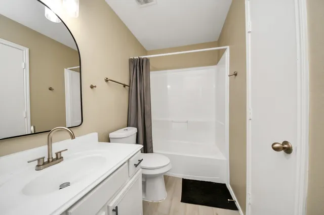 a bathroom with a sink a toilet a shower and a mirror