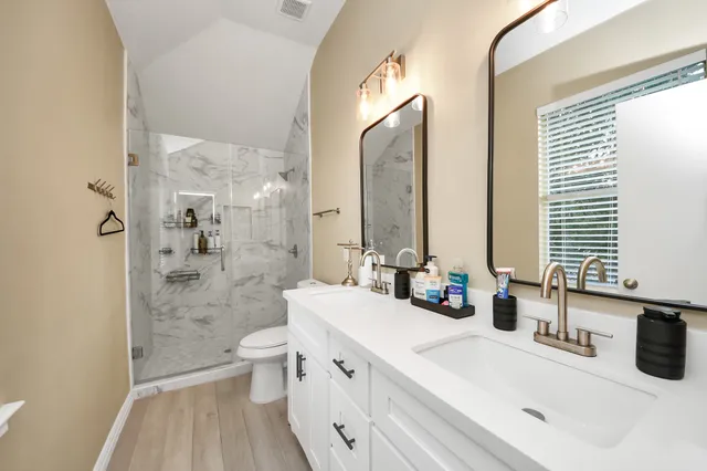 a bathroom with a sink a toilet and a large mirror