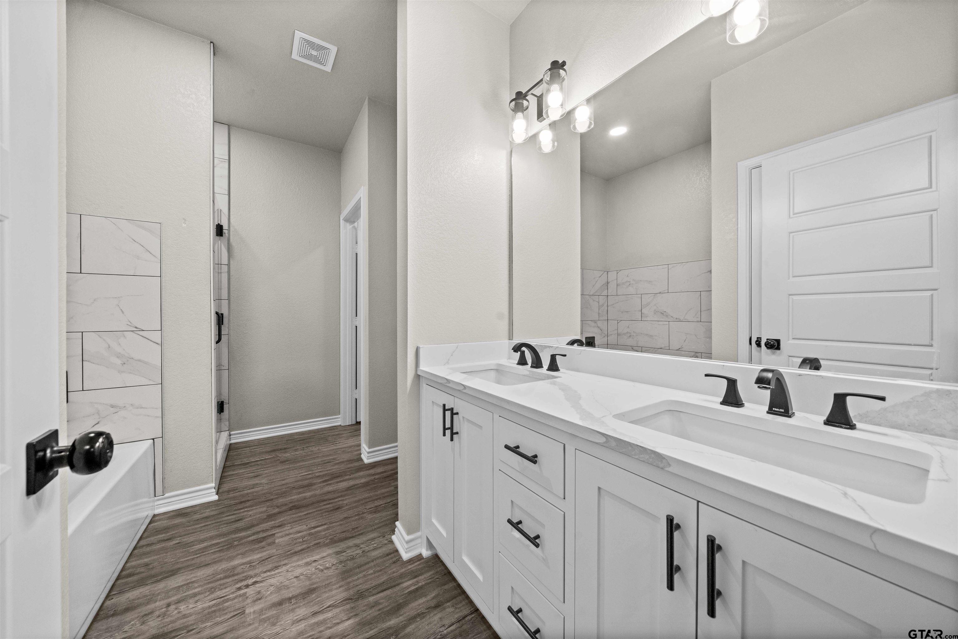 17023 County Road 2282 Troup, TX 75789 - Photo 16 of 30 a bathroom with a double vanity sink a large mirror and shower