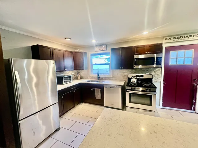 a kitchen with stainless steel appliances granite countertop a refrigerator stove microwave and sink