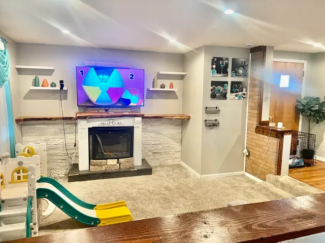 a living room with stainless steel appliances furniture and a flat screen tv