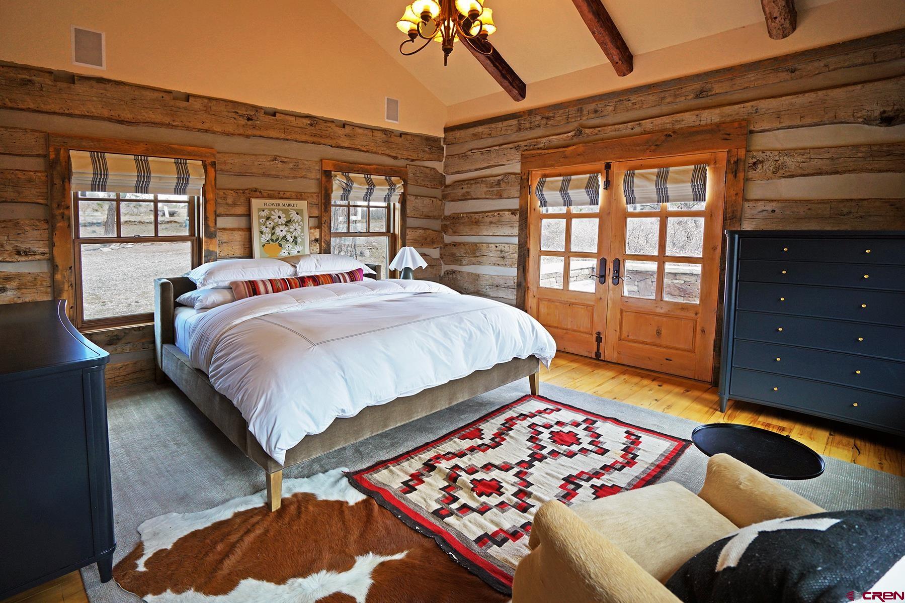 1250 McKenzie Springs Road Placerville, CO 81430 - Photo 35 of 45 a bedroom with a bed and wooden floor