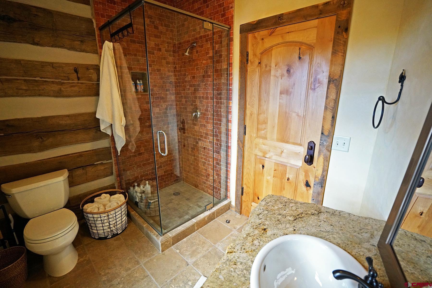 1250 McKenzie Springs Road Placerville, CO 81430 - Photo 38 of 45 a bathroom with a granite countertop sink toilet and shower