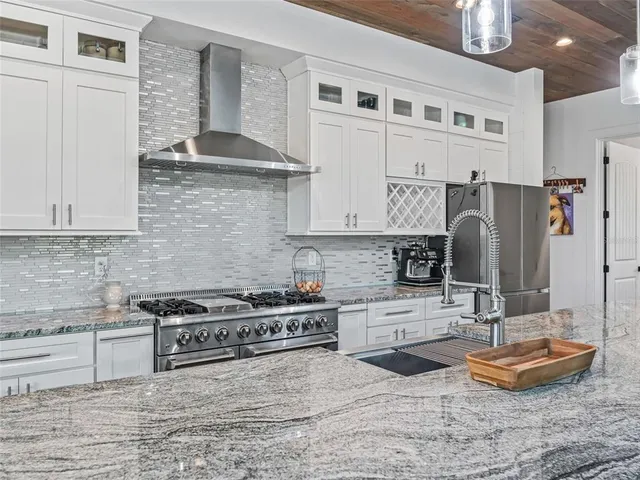 a kitchen with stainless steel appliances granite countertop a stove a sink and a microwave