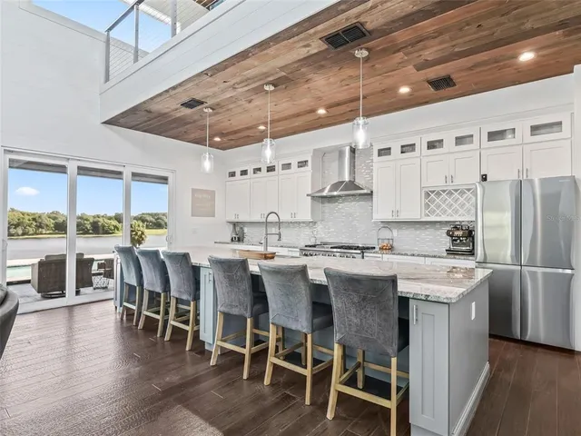 a large kitchen with stainless steel appliances granite countertop a lot of counter space and wooden floors