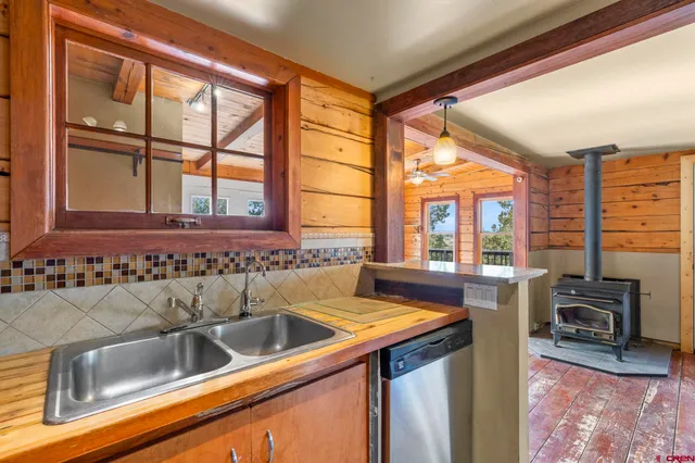 a kitchen with stainless steel appliances granite countertop a sink a stove and a refrigerator