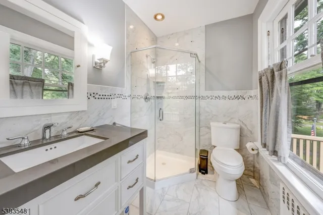 a spacious bathroom with a granite countertop sink toilet and shower
