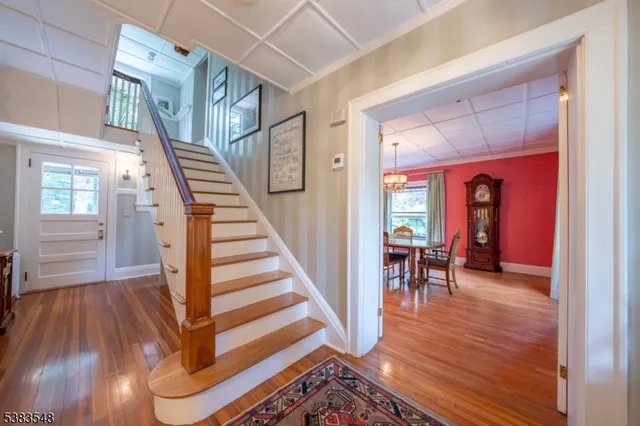 a view of a hallway with wooden floor staircase and windows