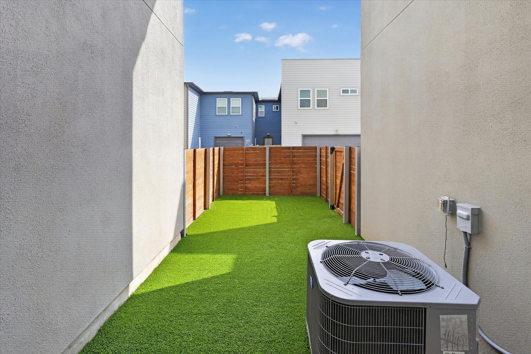 9015 Cattle Baron Path, Unit 1102 Austin, TX 78747 - Photo 21 of 25 A compact backyard with vibrant artificial turf provides a low-maintenance outdoor escape.