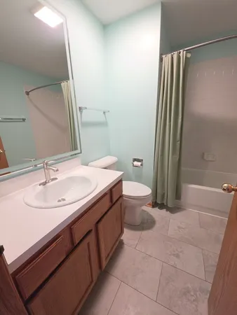 a bathroom with a granite countertop sink toilet and a mirror