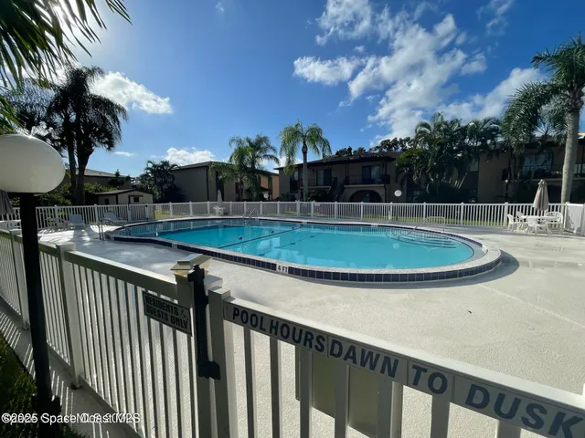 a view of a swimming pool with a patio and a yard