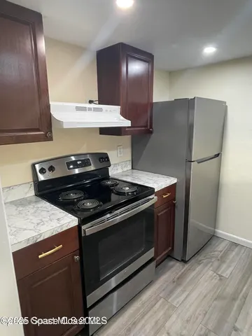 a stove top oven sitting inside of a kitchen