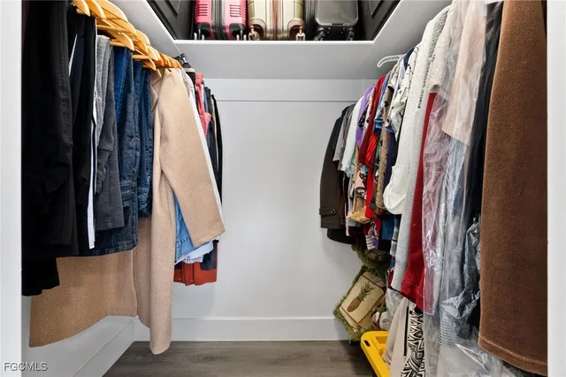 a view of walk in closet with clothes and shoes