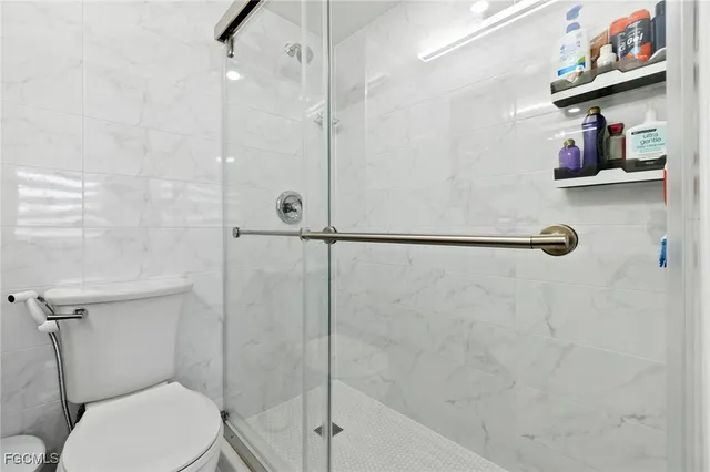 a bathroom with a shower a toilet and a sink