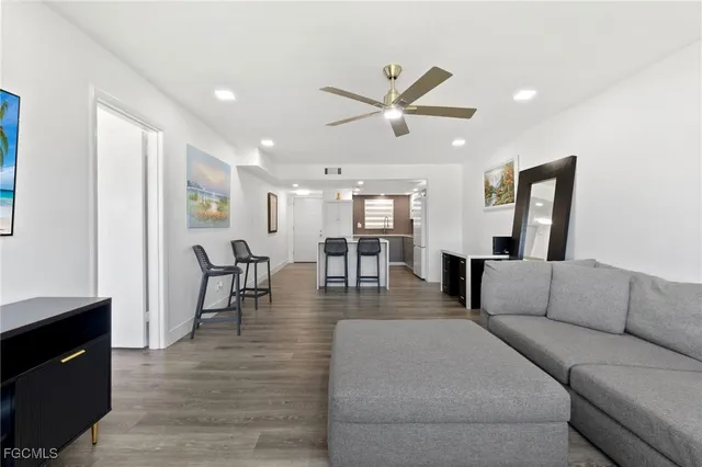 a living room with furniture and a view of kitchen
