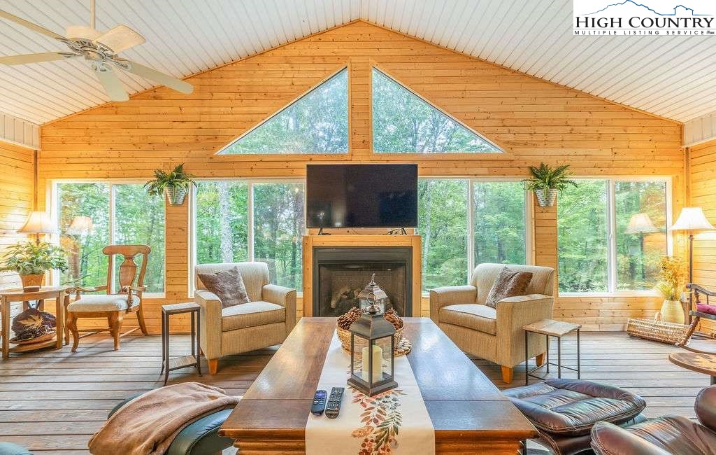 120 Ridge Road Newland, NC 28657 - Photo 13 of 40 a living room with furniture a fireplace and floor to ceiling windows