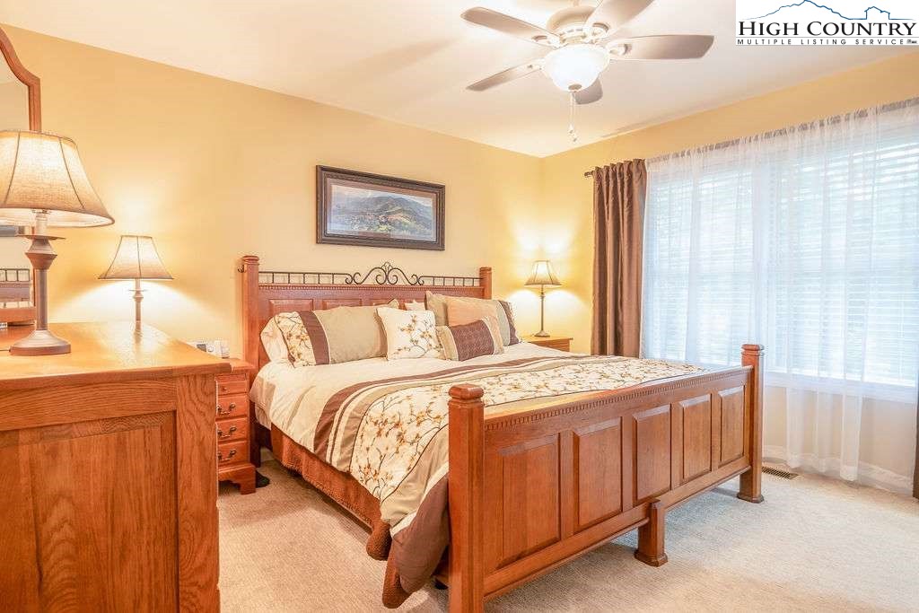 120 Ridge Road Newland, NC 28657 - Photo 15 of 40 a bedroom with a bed and a chandelier