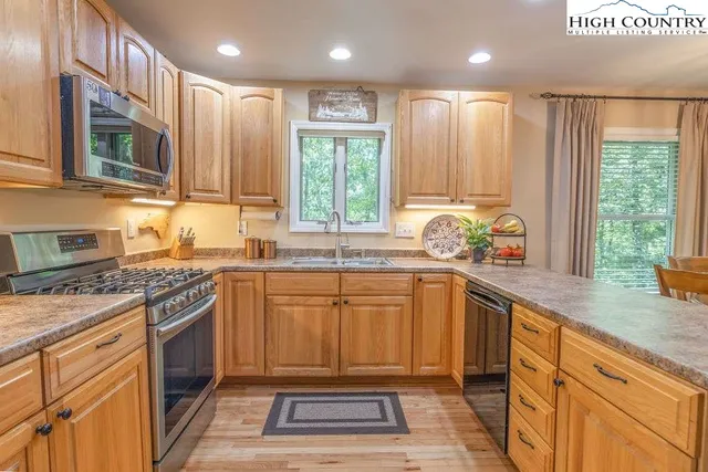 a kitchen with stainless steel appliances granite countertop a stove a sink and a microwave