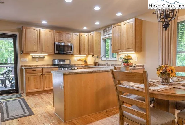 a kitchen with kitchen island granite countertop a sink cabinets and stainless steel appliances