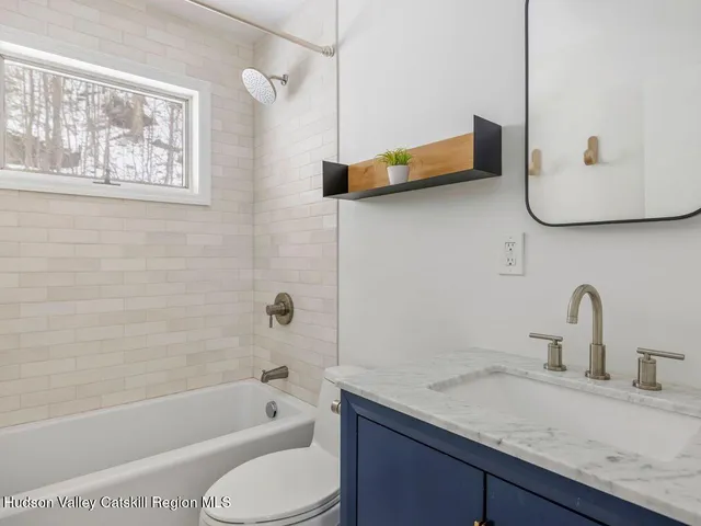 a bathroom with a granite countertop sink toilet and bathtub