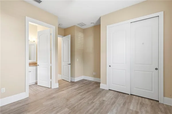 an empty room with closet and wooden floor