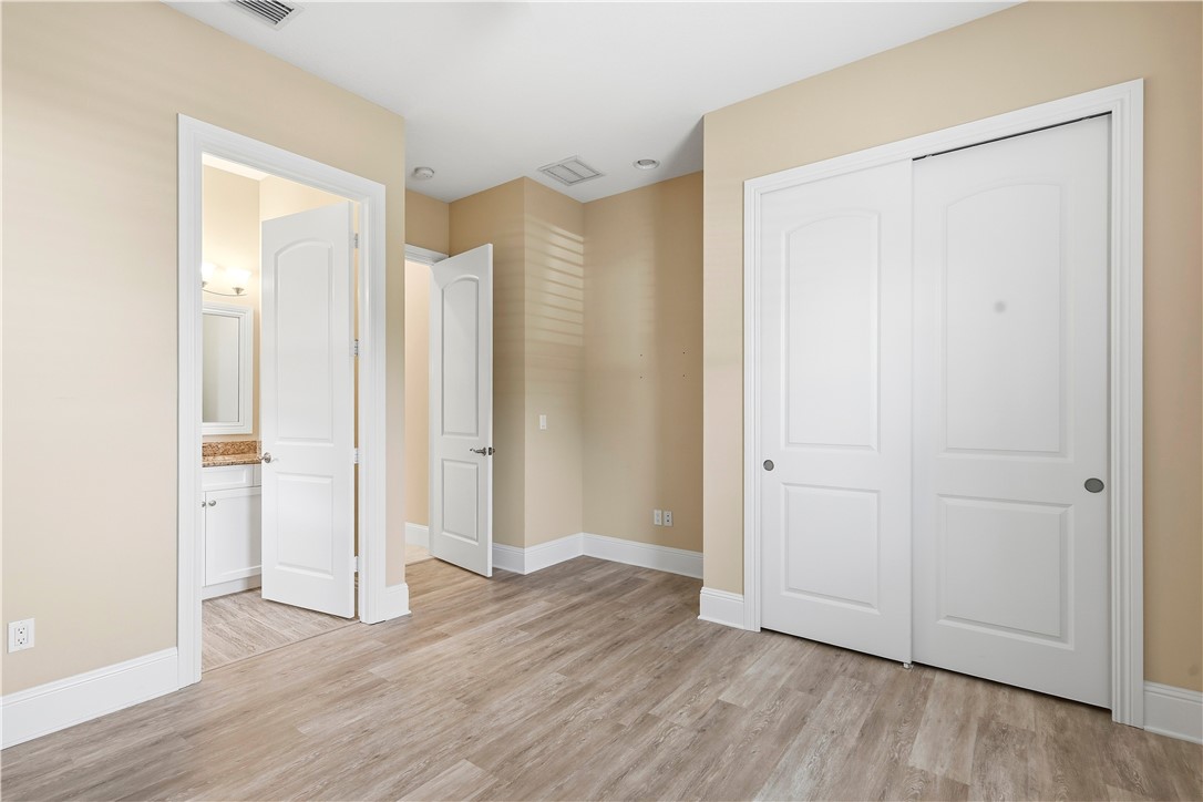 2030 Bridgepointe Circle, Unit 112 Vero Beach, FL 32967 - Photo 13 of 36 an empty room with closet and wooden floor