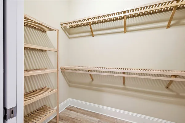 a view of walk in closet with clothes and shoes