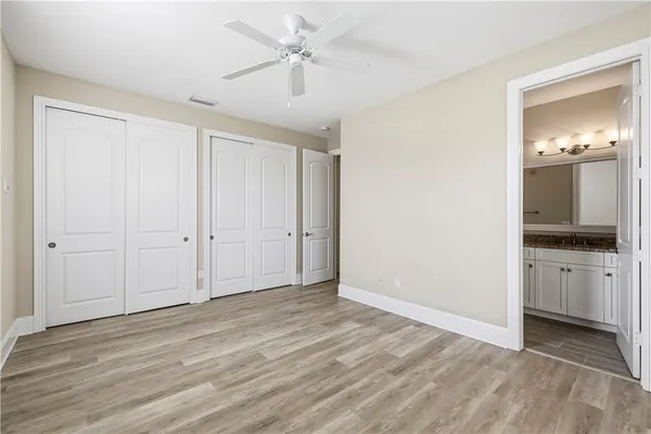 a view of a livingroom with a chandelier fan and wooden floor