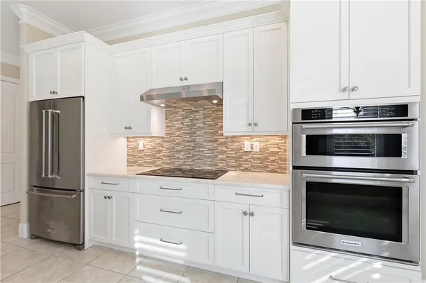 a kitchen with granite countertop white cabinets and stainless steel appliances