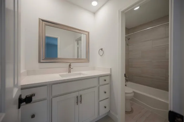 a bathroom with a bathtub sink vanity and mirror