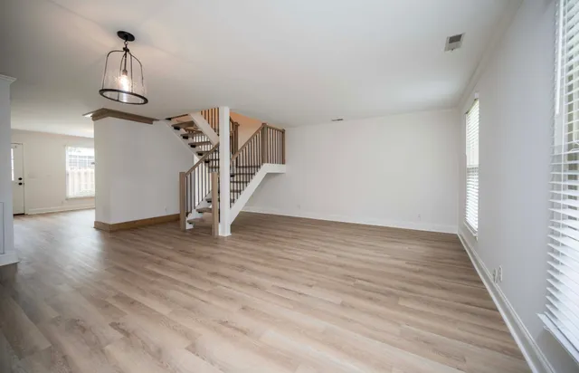 a view of empty room with wooden floor