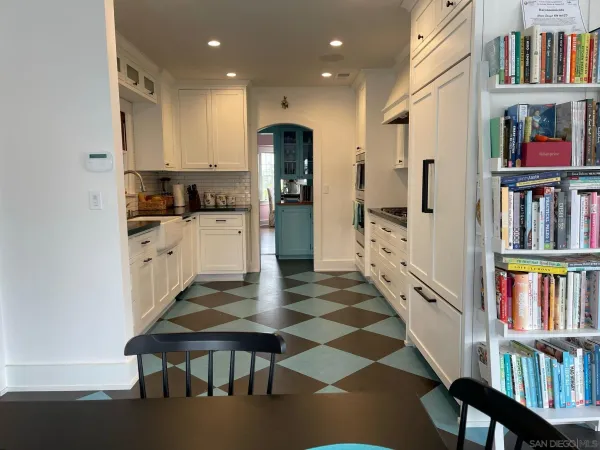 a kitchen with stainless steel appliances granite countertop a refrigerator and a dining table