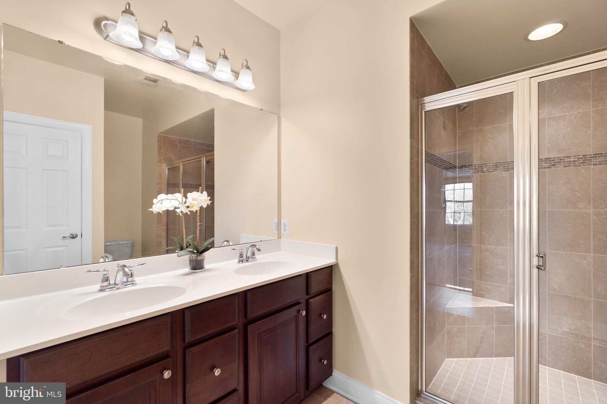 3624 Spring Hollow Lane Frederick, MD 21704 - Photo 18 of 46 a bathroom with a double vanity sink and mirror