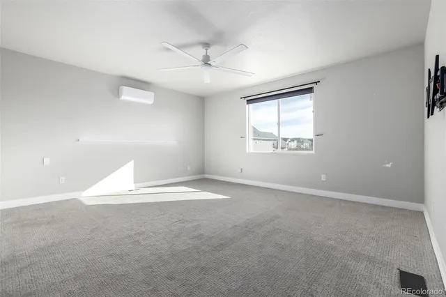 an empty room with a window and ceiling fan