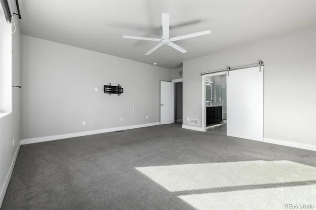 an empty room with closet and windows