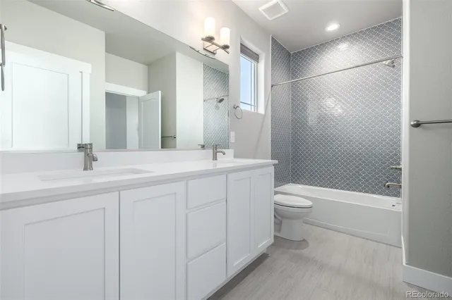 a bathroom with a double vanity sink toilet and shower