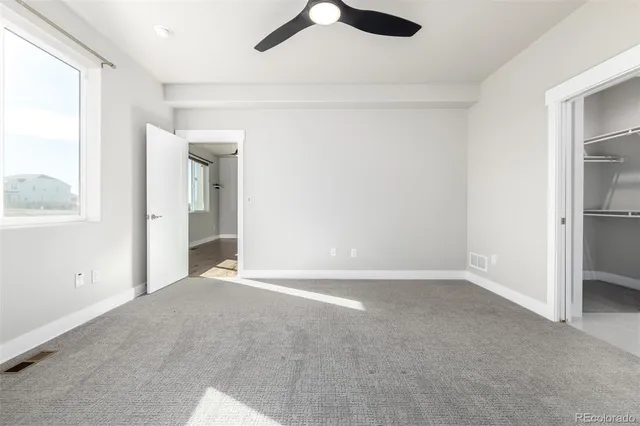 an empty room with fan and windows