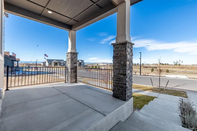 a view of a balcony with floor to ceiling windows wooden fence and city view