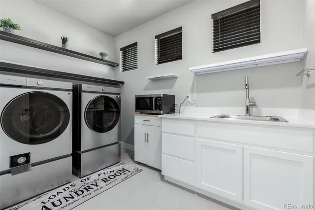a utility room with sink dryer and washer