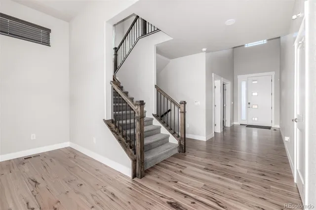a view of a hallway with wooden floor and staircase