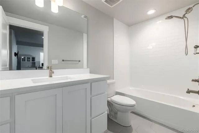a bathroom with a granite countertop sink a toilet and a bathtub