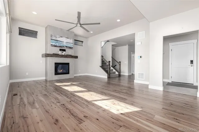 a view of empty room with wooden floor and fireplace