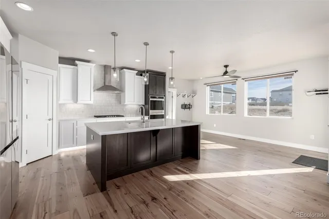 a large kitchen with stainless steel appliances granite countertop a stove a sink and a refrigerator