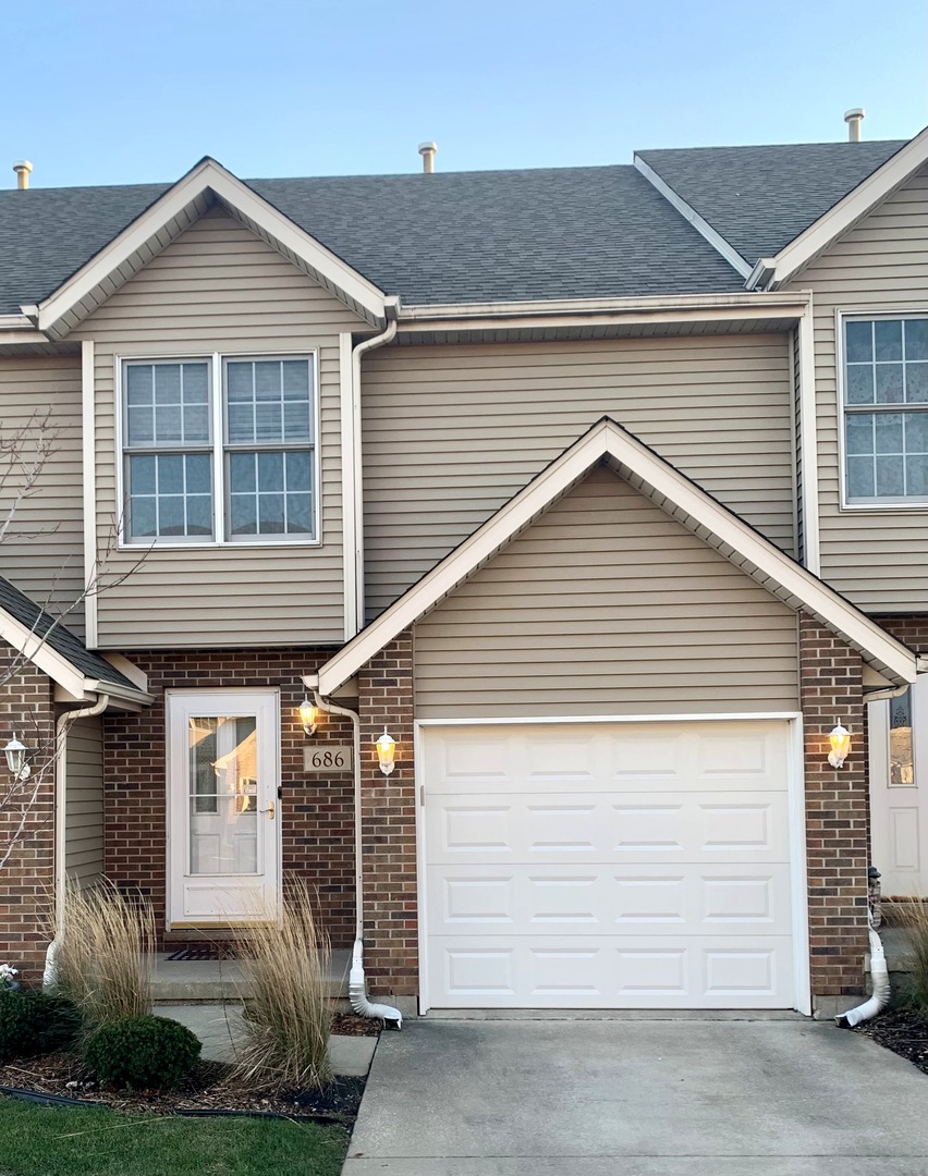 686 South Peace Road, Unit 686 Sycamore, IL 60178 - Photo 2 of 15 a front view of a house with a yard and garage