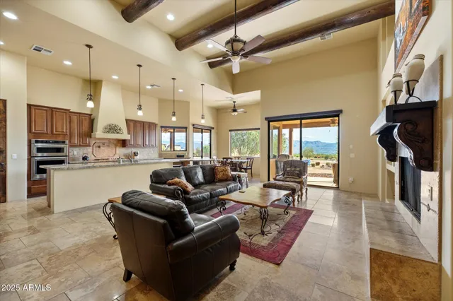 a living room with stainless steel appliances furniture a rug and a kitchen view