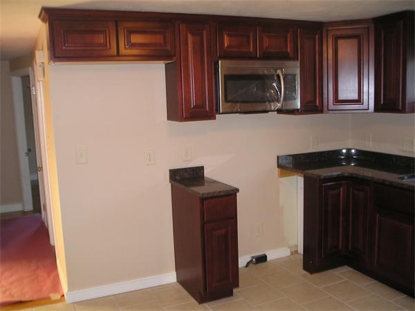 661 Plumtree Road Springfield, MA 01118 - Photo 3 of 10 a kitchen with granite countertop wooden cabinets and a microwave oven