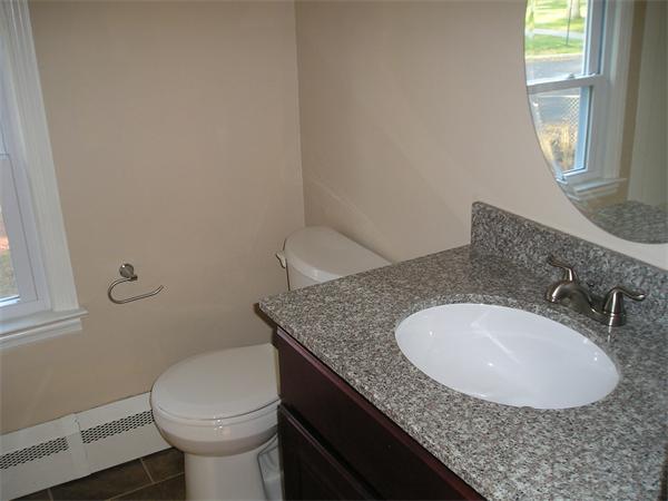 661 Plumtree Road Springfield, MA 01118 - Photo 7 of 10 a bathroom with a granite countertop sink a toilet and a mirror