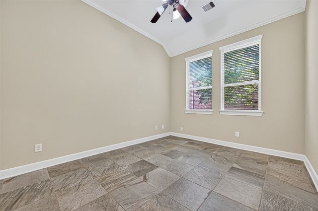 a view of an empty room with a window and a ceiling fan
