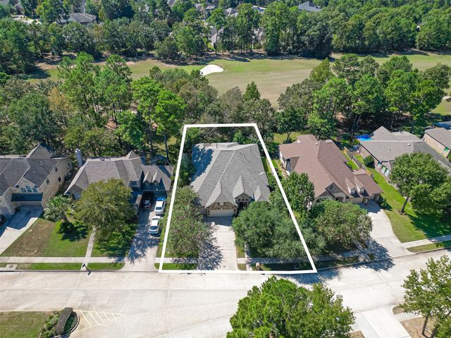 an aerial view of a house with a yard and lake view