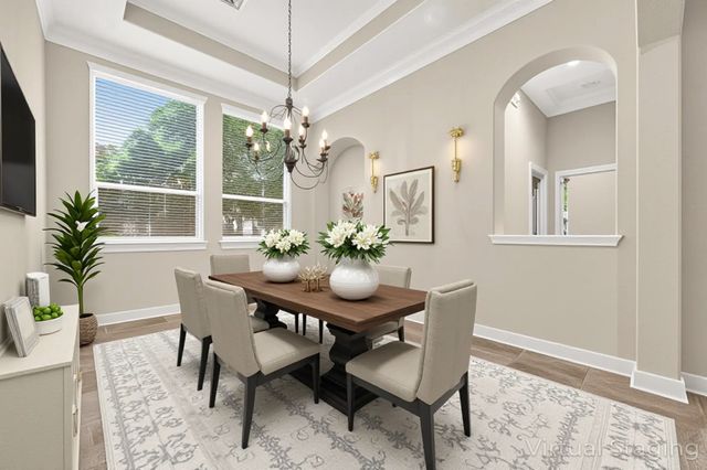 a dining room with furniture a chandelier and wooden floor